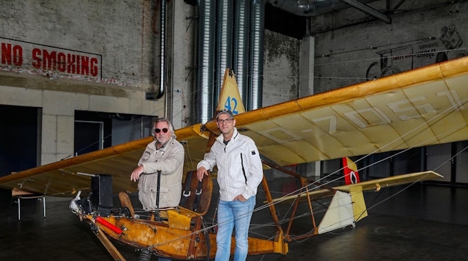 Tommy Engel steht neben Marc Metzger an einem alten Holzflugzeug