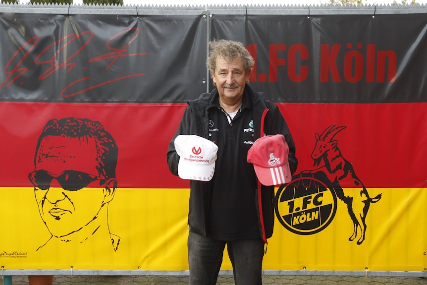 Fanclub-Vorsitzender Reiner Ferling steht vor seiner großen Deutschland-Fahne an seinem Haus: Er schwärmt für Michael Schumacher und den 1. FC Köln.