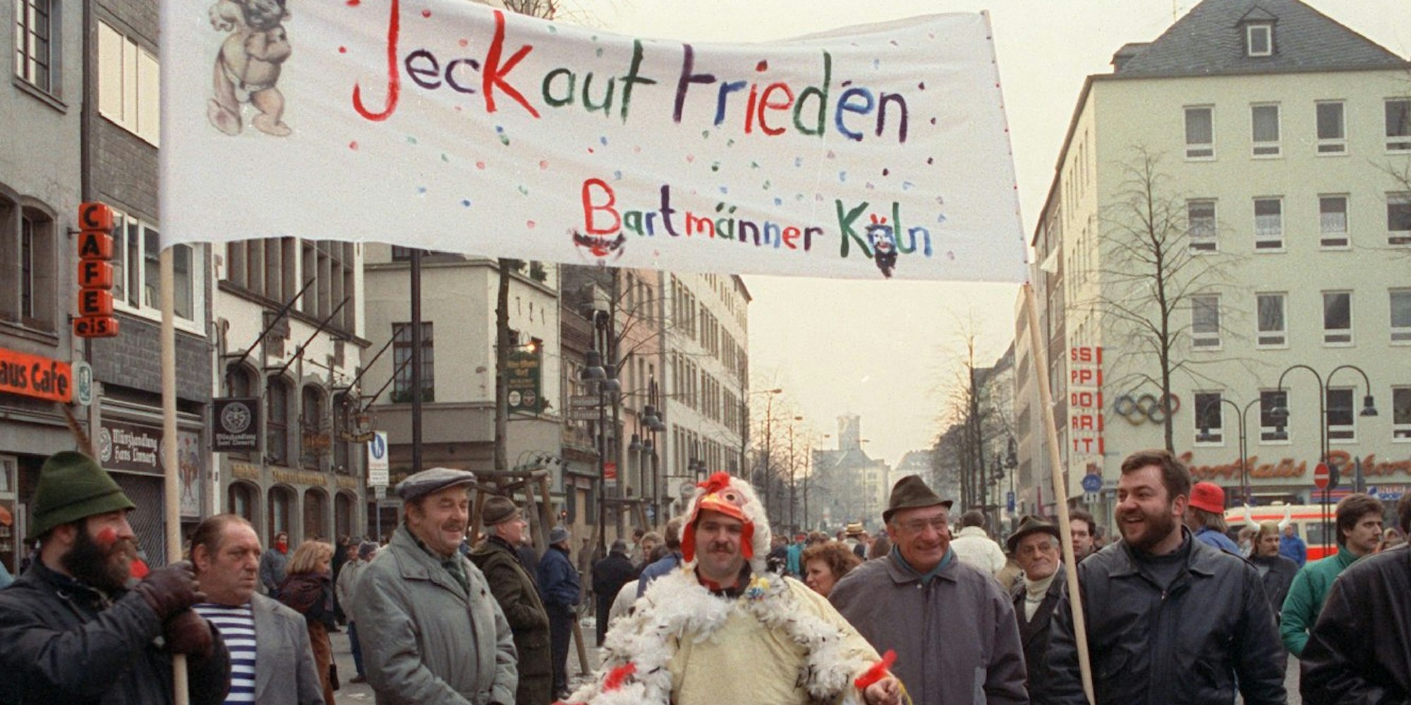 „Jeck auf Frieden“ steht auf einem Transparent, das Mitglieder des Karnevalsvereins "Bartmänner Köln" am 7.2.1991 in Köln.