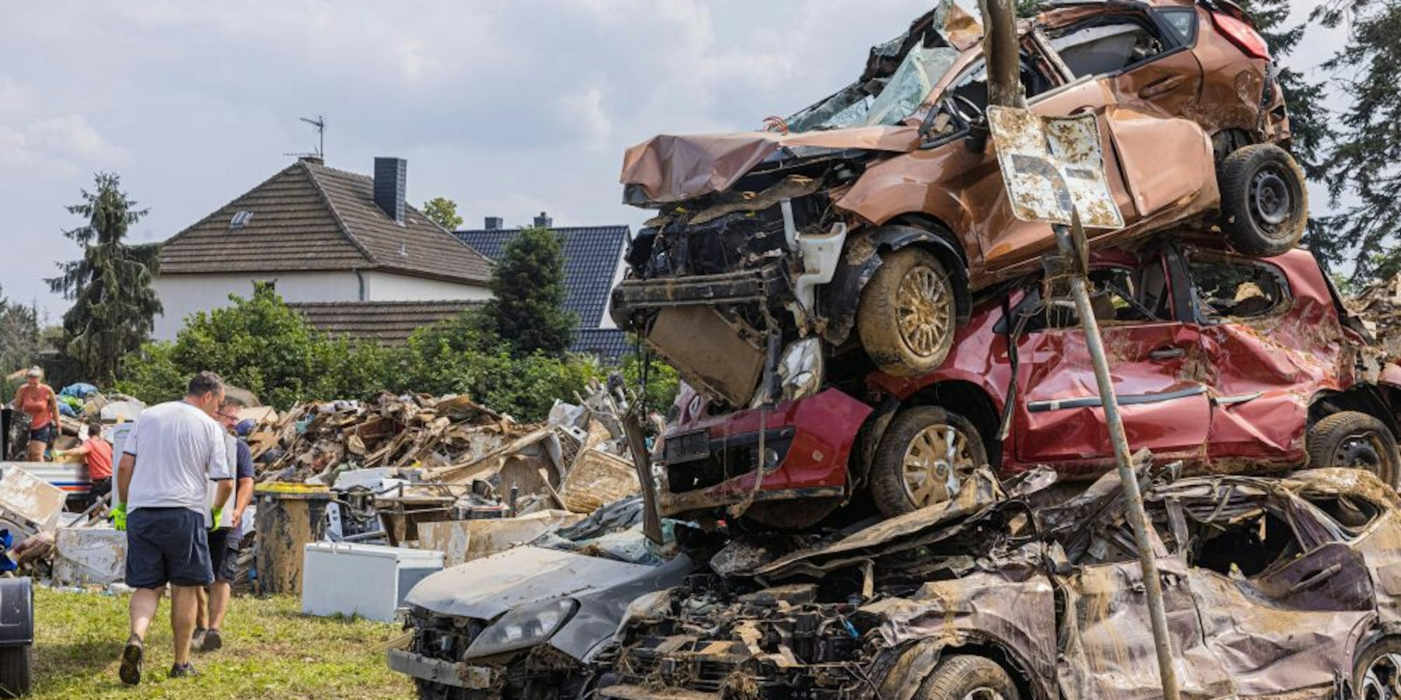 Von der Flut zerstörte Autos stapeln sich in Odendorf