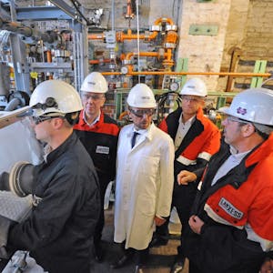 Hubert Fink, Oberbürgermeister Uwe Richrath, Michael Ertl und Thomas Hellmich (v. links) schauen beim Umfüllen von Schwefelsäure zu.