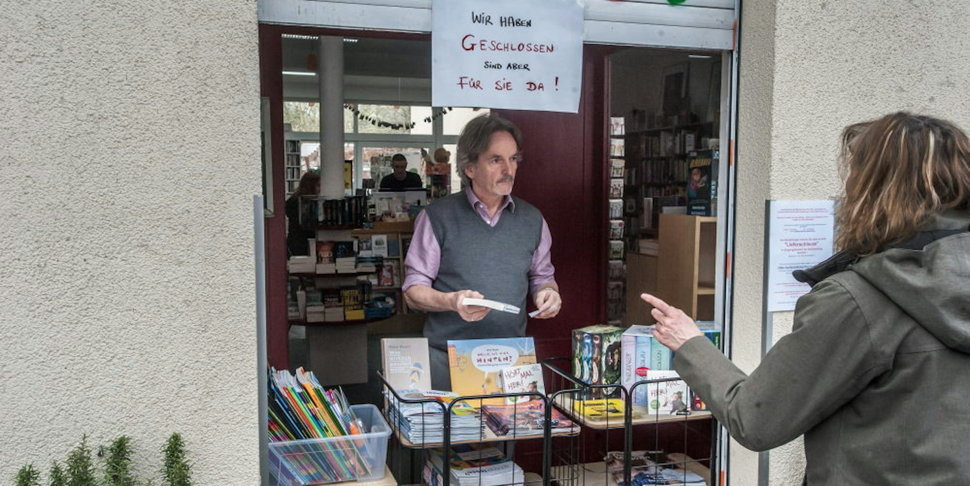 Buchhändler Manfred Gottschalk (l) hat an seinem Geschäft eine Lieferschleuse aufgebaut