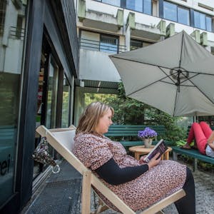 Entspannt im Liegestuhl und unterm Sonnenschirm lesen: Angelina Götz (l.) und Susanne Ohligschläger vom Büchereiteam probieren es aus.
