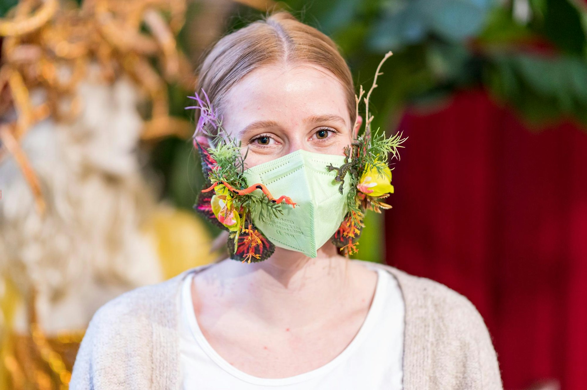 Eine grüne Maske lässt sich mit Blättern und Blüten verschönern.
