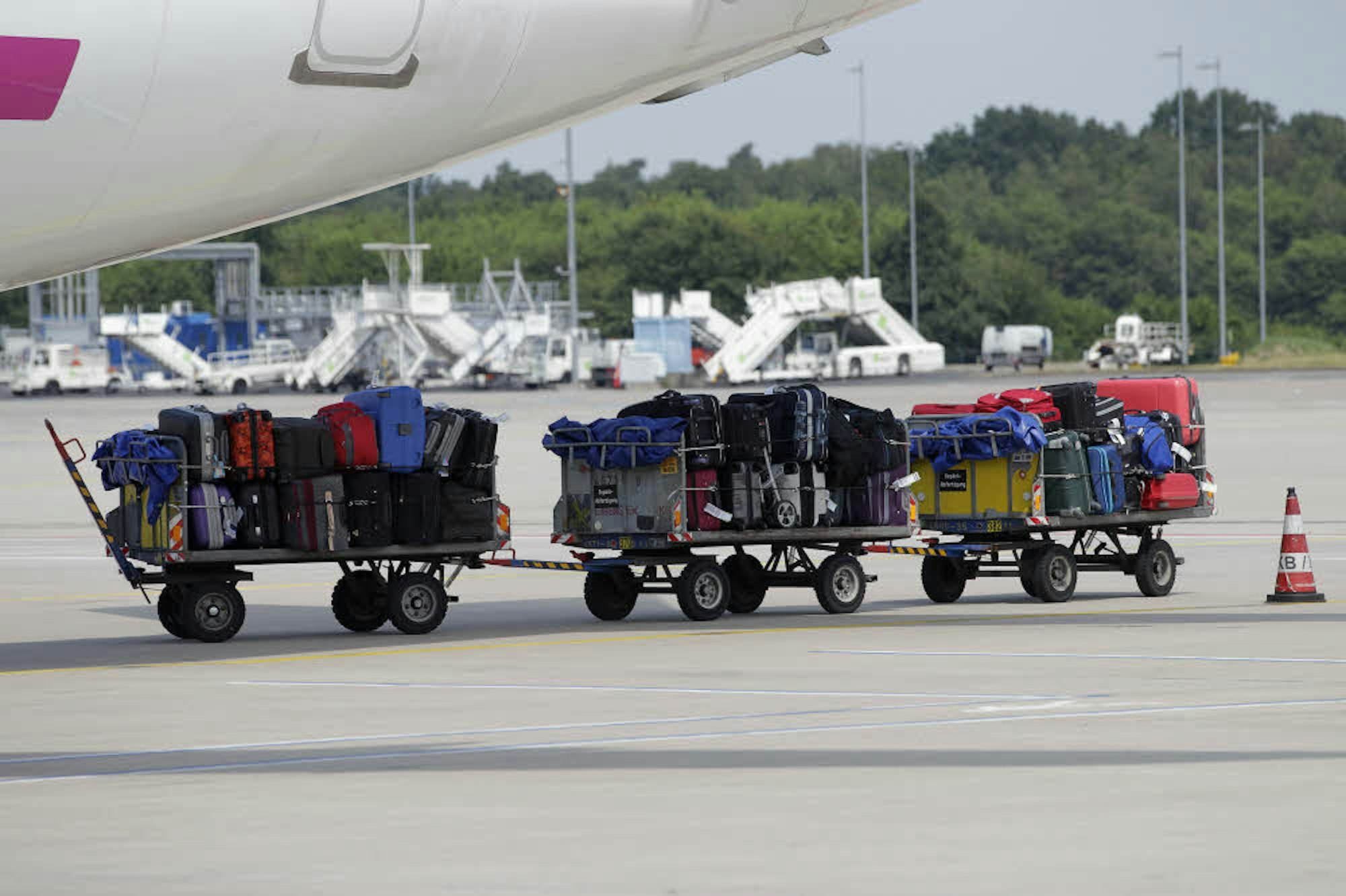 Die Gepäckwagen werden übers Rollfeld zum Flieger gezogen.