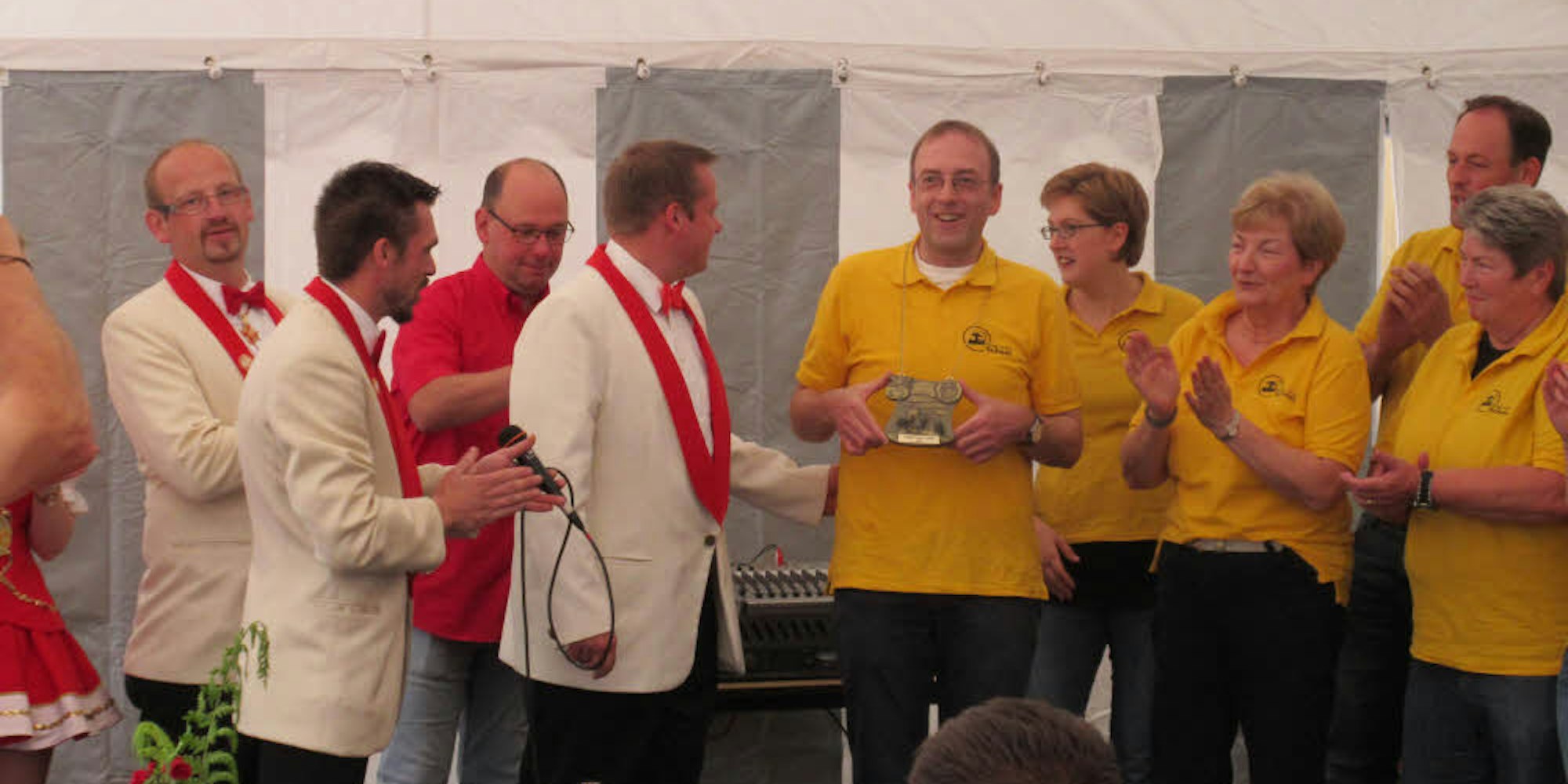 Rot-Weiß würdigt Gelb-Schwarz: Dietmar Klein (5. von rechts) nimmt stellvertretend den Heimatorden entgegend.