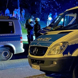 Mannschaftswagen der Kölner Polizei und Beamte stehen am Aachener Weiher.