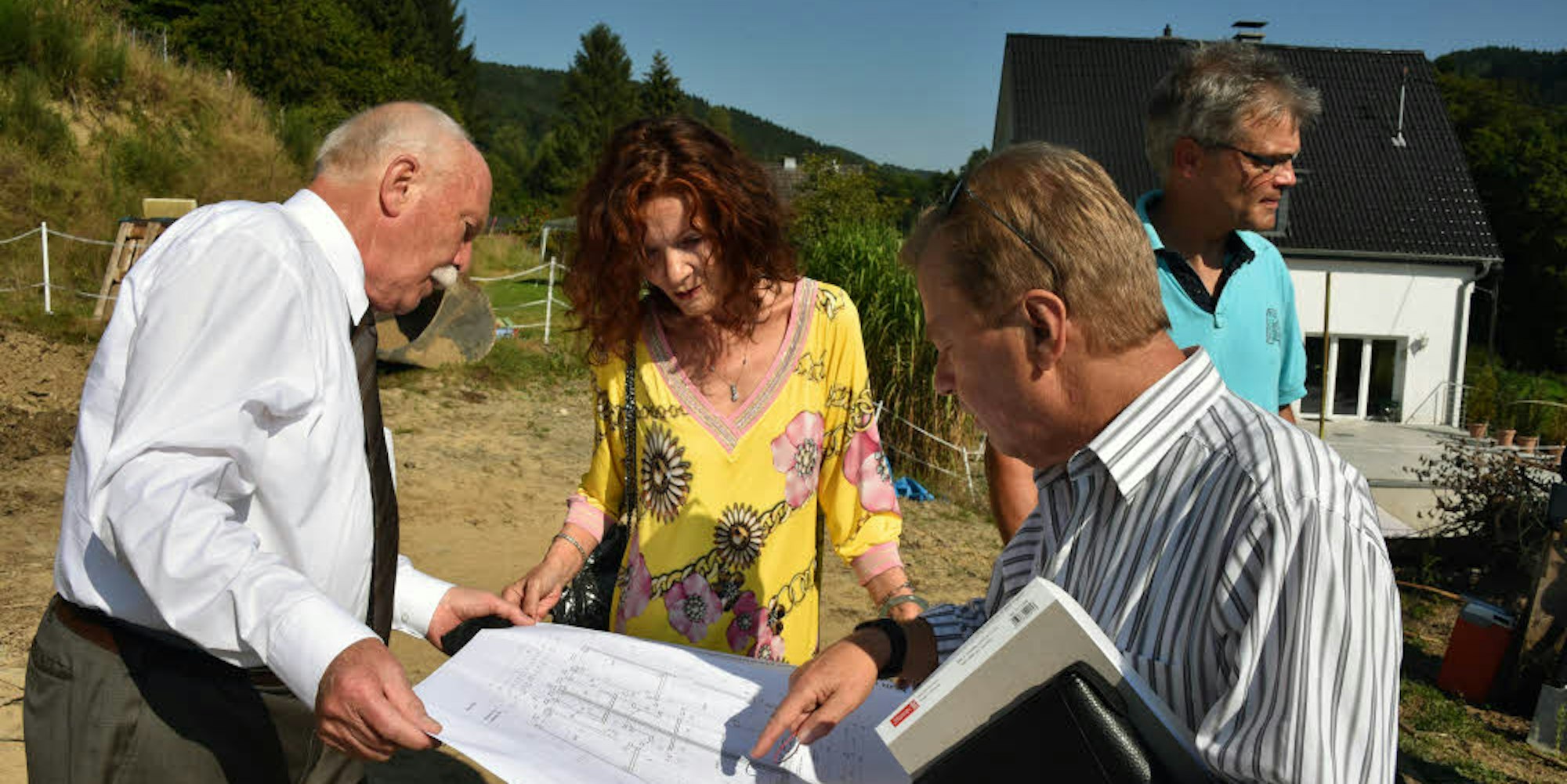 Reinhard Zeppenfeld (80, l.), seine Frau Marcy und Architekt Bernhard Schölzel mit den Plänen auf dem Baugrundstück.