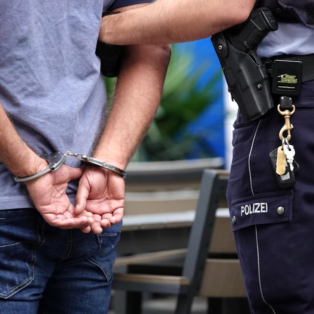 Ein Mann in Handschellen wird festgenommen.