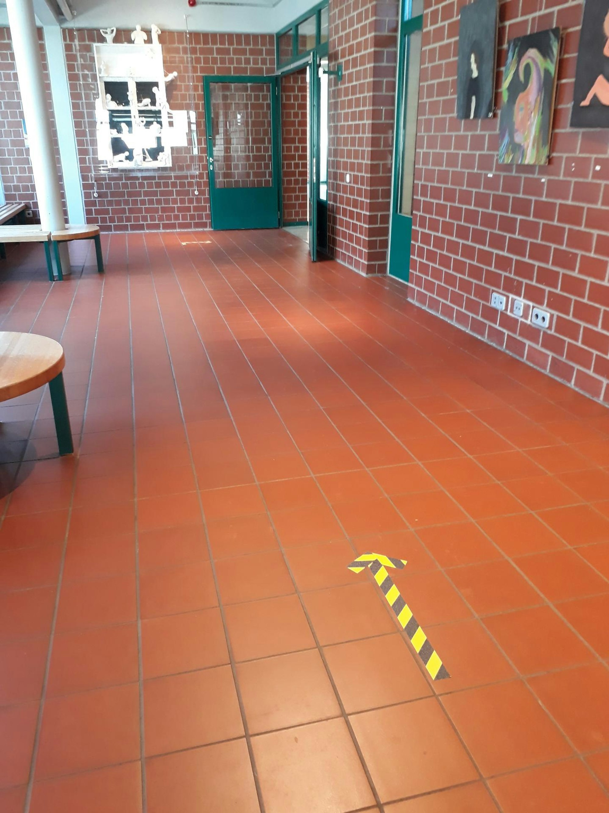 Aufgeklebte Pfeile auf dem Fußboden sollen sicherstellen, dass die Abstandsregeln eingehalten werden.