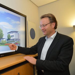 Anhand einer Planansicht erläutert Geschäftsführer Marcus Otto Details die Gestaltung des neuen Gebäudes der Kreishandwerkerschaft in Bergisch Gladbach.