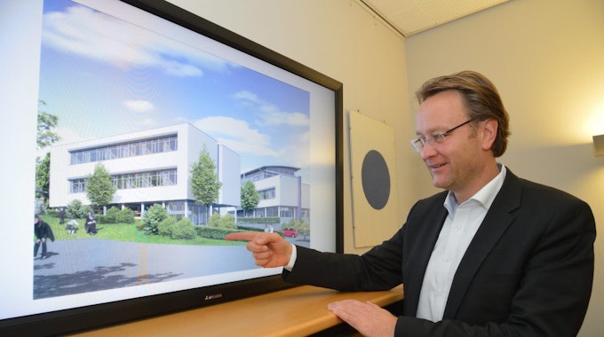 Anhand einer Planansicht erläutert Geschäftsführer Marcus Otto Details die Gestaltung des neuen Gebäudes der Kreishandwerkerschaft in Bergisch Gladbach.