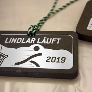 Teilnehmermedaille des Lindlarer Ortskernlaufs 2019. Die Medaillen werden aus dem Naturstein Grauwacke hergestellt.