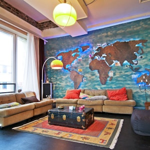 An der Wand eine riesige Weltkarte, ein alter Koffer als Couchtisch: So sieht's im Loft von Alex aus.