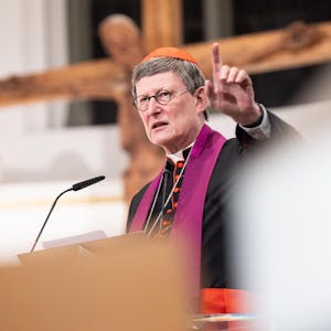 Kardinal Woelki steht vor einem Kreuz