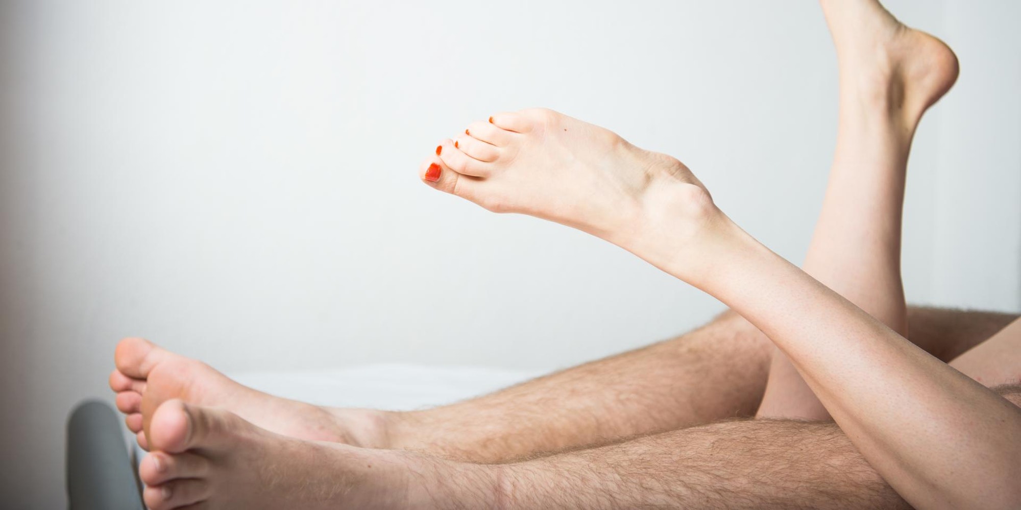 Zwei Menschen haben Sex, die Füße gucken raus