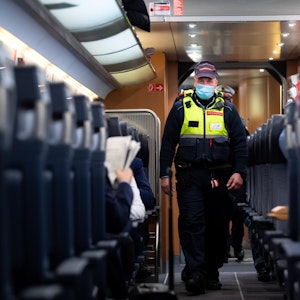 Das undatierte Symbolfoto zeigt einen Polizisten, der durch einen Zug läuft.