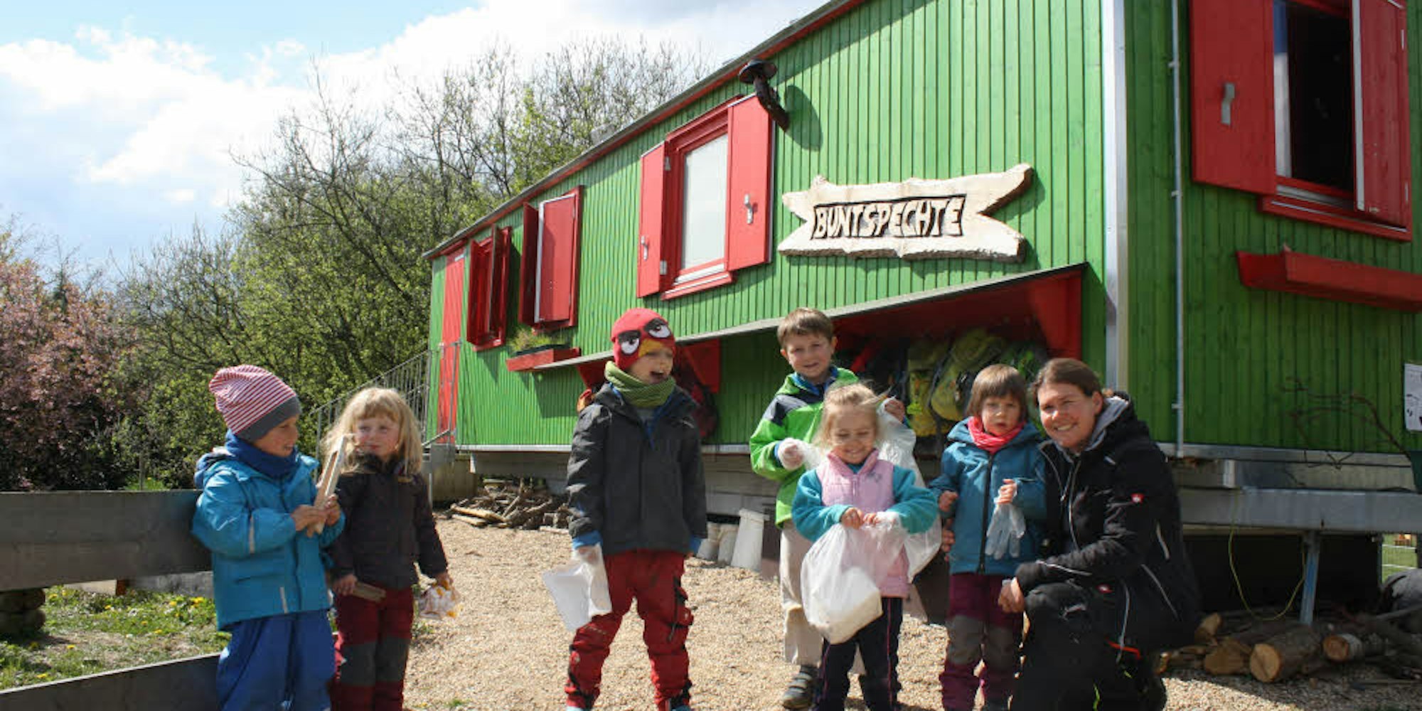 Die Kinder der Domino-Waldgruppe vor ihrem Bauwagen, das Foto entstand bei der Müllsammel-Aktion im April 2017.
