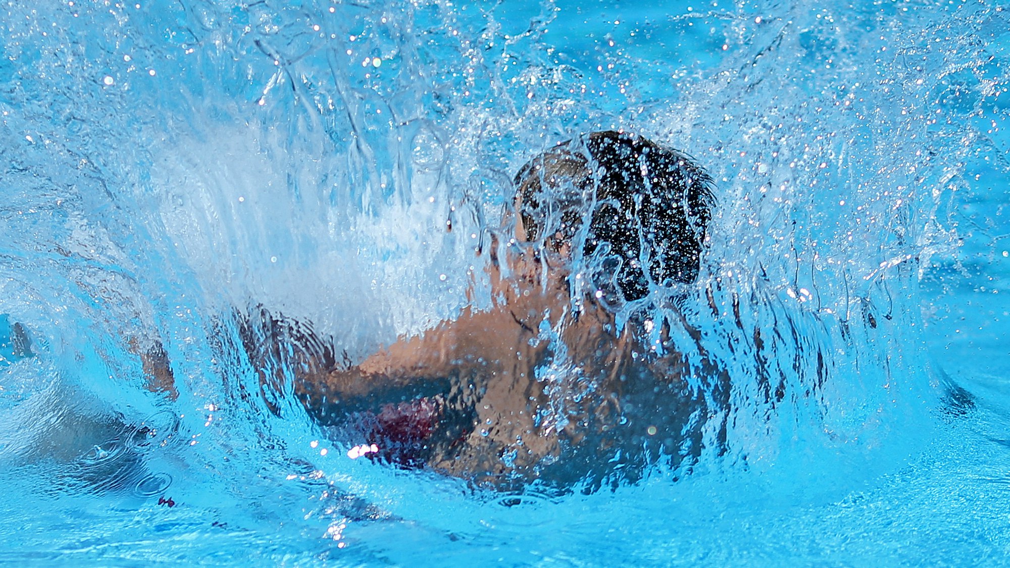 Ein Kind springt in ein Schwimmbecken