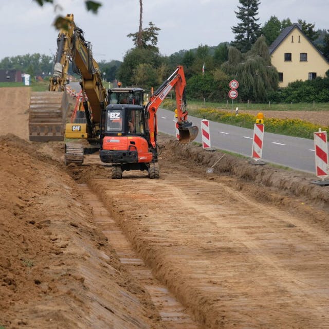 Auf der südlichen Seite der Landstraße 163 haben Bauarbeiter mit Baggern begonnen, den Radweg zu realisieren.