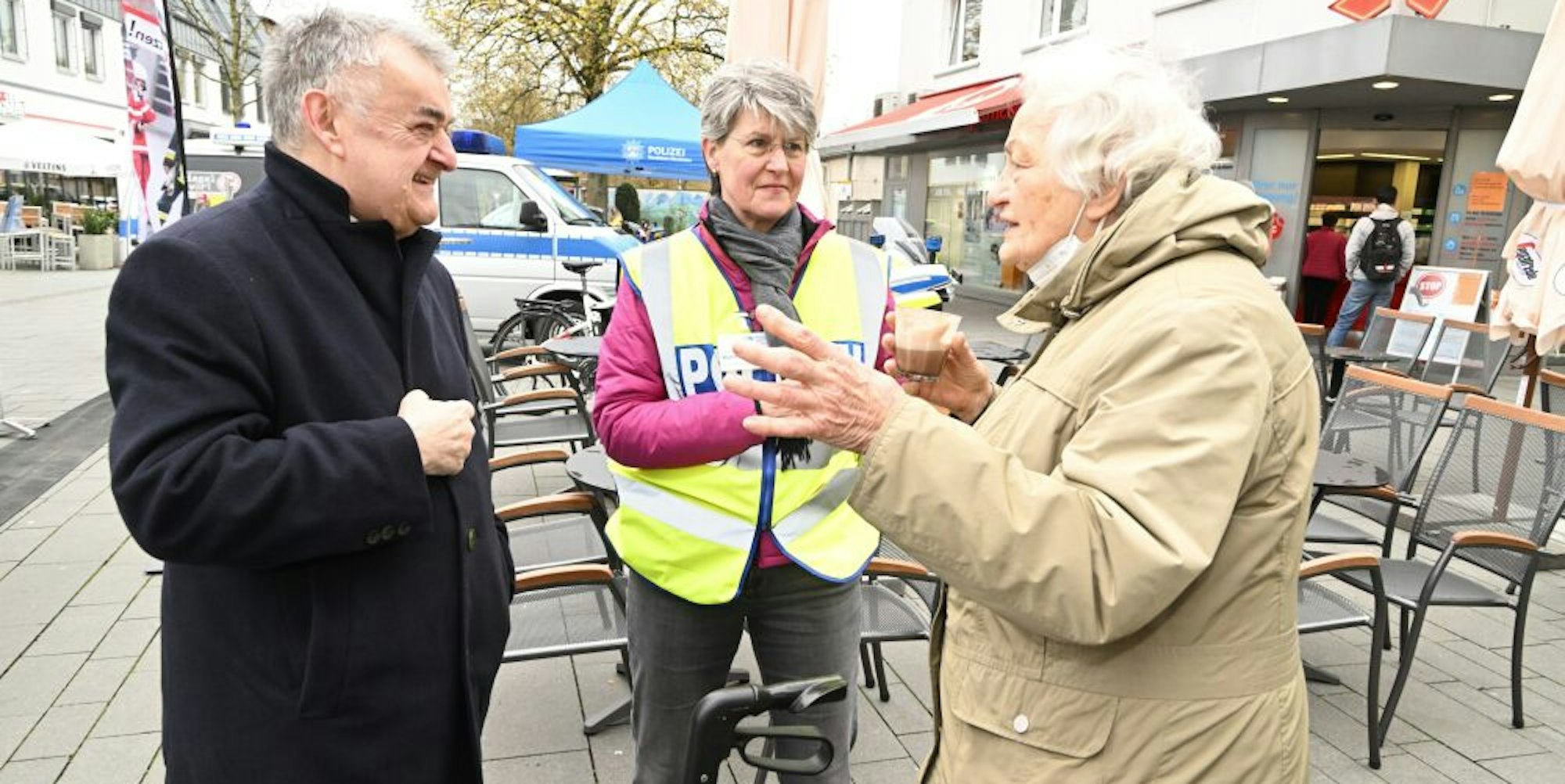 NRW-Innenminister Herbert Reul (linkes Bild, l.) im Gespräch mit Helga Henk (r.) und Claudia Kammann. Am Café-Mobil (rechtes Bild) kamen am Mittwoch zahlreiche Bürgerinnen und Bürger mit der Polizei „auf einen Kaffee“ ins Gespräch.