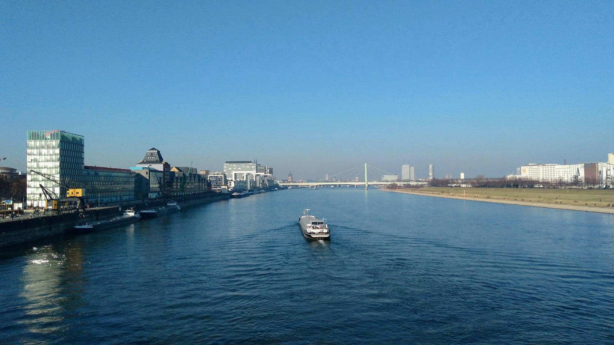 Blick auf ein Schiff auf dem Rhein, darüber blauer Himmel