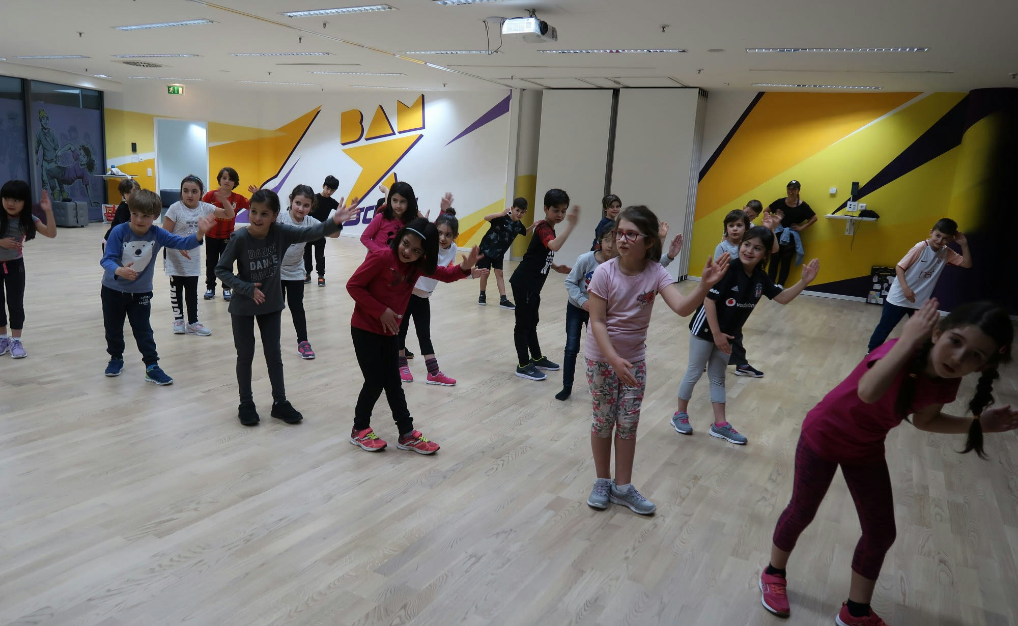 Angeleitet von den Tanztrainern üben die Schüler die synchronen Choreografie-Schritte ein.