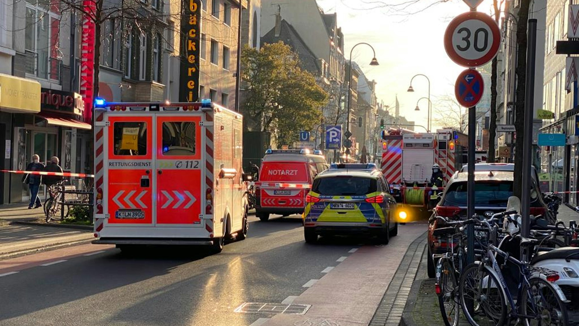Die Venloer Straße ist abgesperrt, dort steht ein Streifenwagen, ein RTW sowie Fahrzeuge von Notarzt und Feuerwehr.