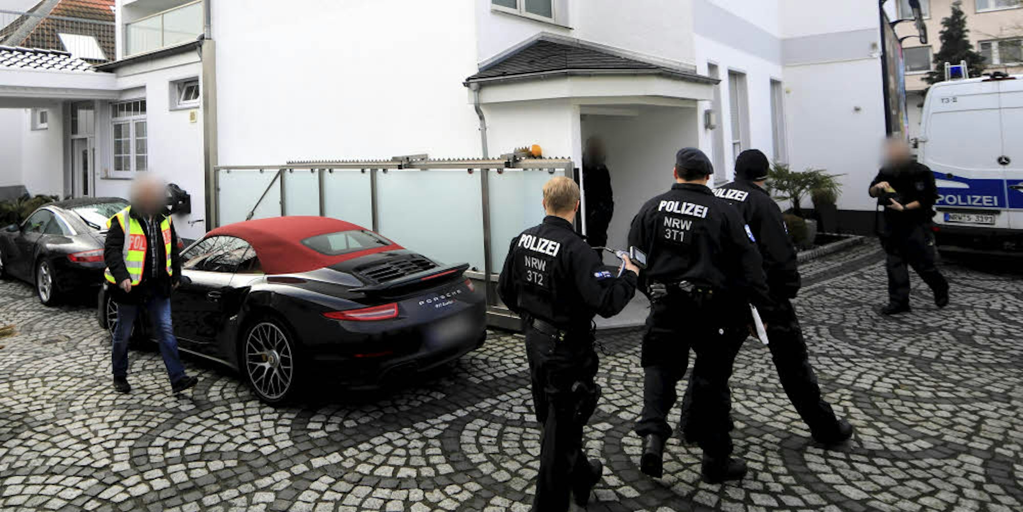 Beamte bei der Razzia in Leverkusen vor dem Haus des Verdächtigen.