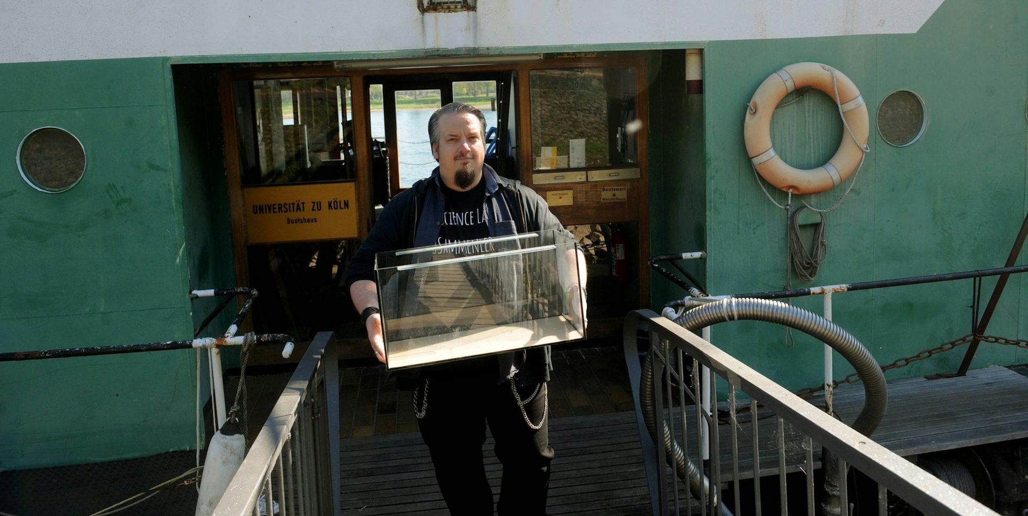 Maik Schössow transportiert eines von vielen Aquarien aus der Ökologischen Rheinstation.