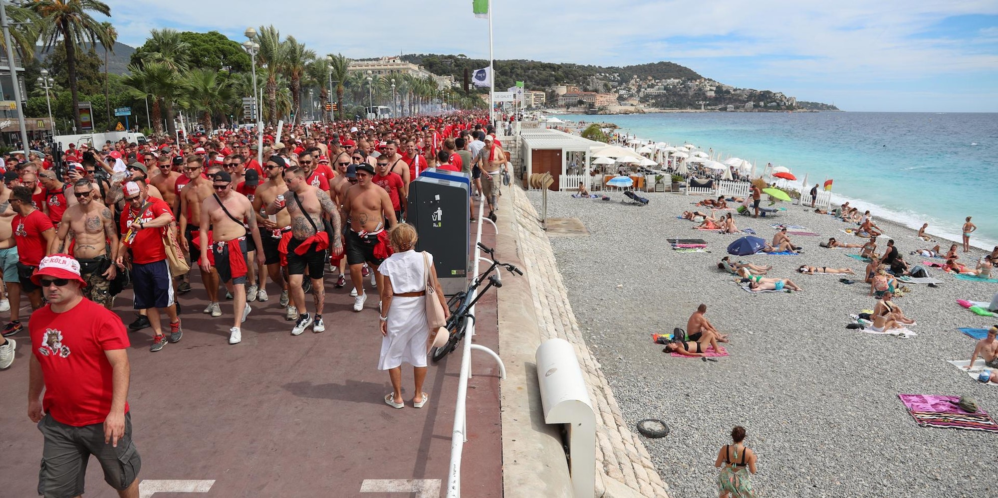Fans marschieren am Strand vorbe