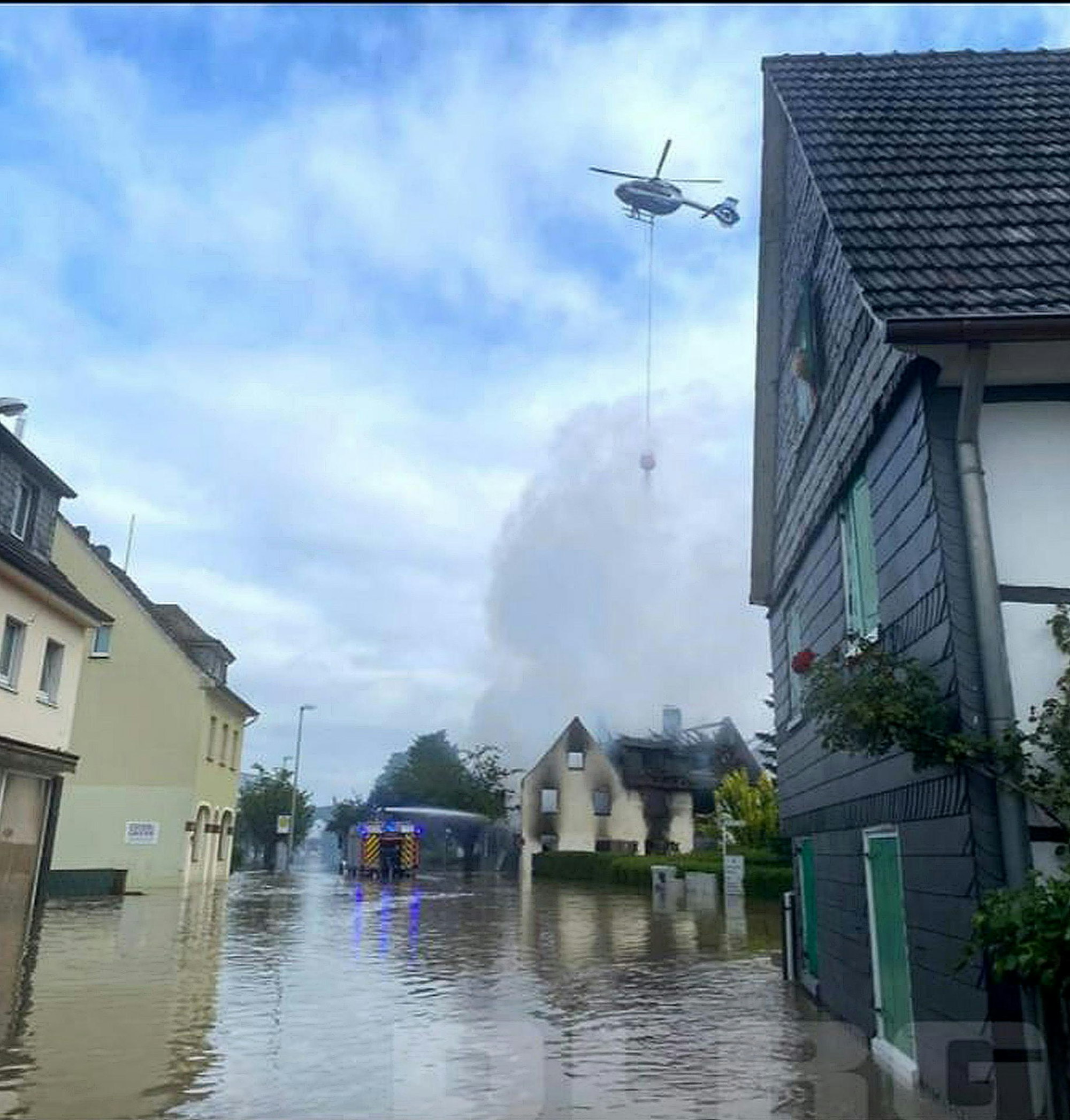 Lösch-Hubschrauber über dem brennenden Haus.