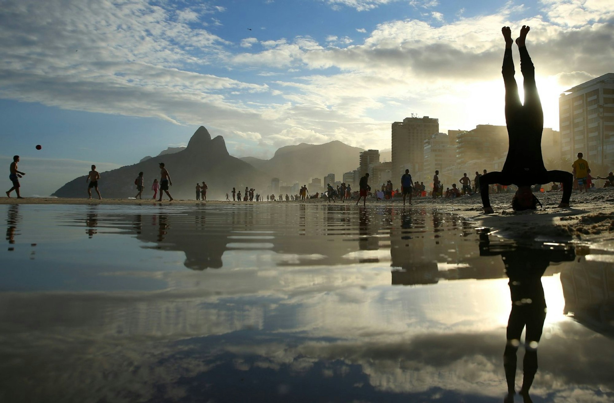 Die Perspektive wechseln: Das geht, wenn man sich auf ein unbekanntes Reiseziel einlässt – oder einen Kopfstand macht, wie hier am Strand von Ipanema, Rio de Janeiro, Brasilien.