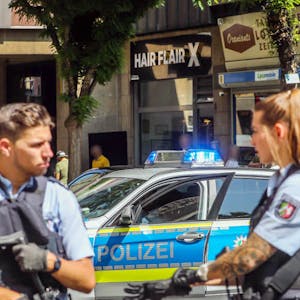Polizisten riegeln den Dortmunder Friseurladen nach dem Überfall ab.