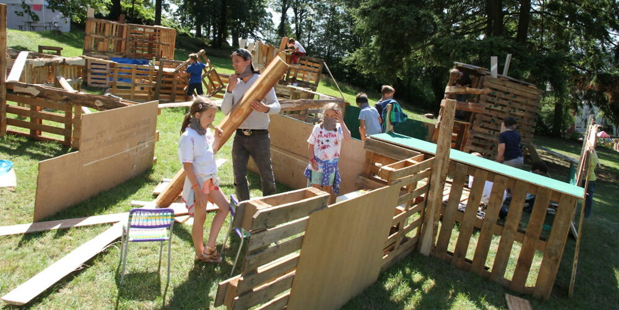 Aus Holzpaletten bauen die Kinder ihr eigenes Dorf. Auch ein Versammlungsplatz gehört dazu.