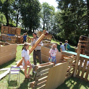 Aus Holzpaletten bauen die Kinder ihr eigenes Dorf. Auch ein Versammlungsplatz gehört dazu.