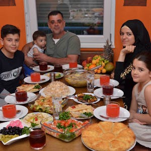 Fastenbrechen im Ramadan: Anoar Abo Harb (mit Kopftuch) und ihr Bruder Yassin,Vater Jamil Abo Harb und Schwester Nezma sitzen am reich gedeckten Tisch in ihrer Wohnung in der Flüchtlingsunterkunft in Siegburg.