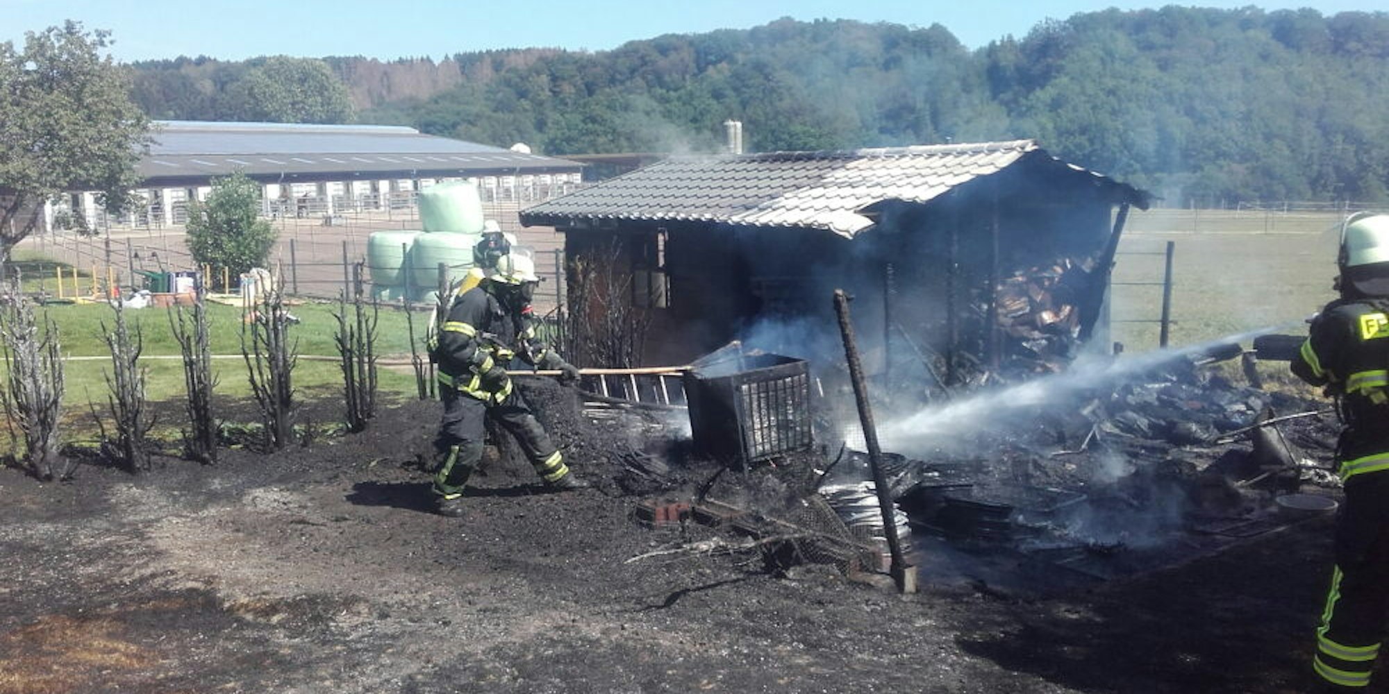 Mit zwei C-Rohren ging die Feuerwehr in Unterbüschem gegen die Flammen vor. Das Feuer war vom Gartenhaus auf eine Tuja-Hecke und den Rasen übergesprungen.