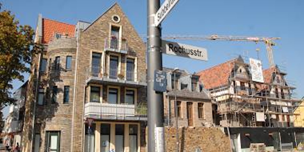 Ein angedeuteter Turm markiert das Eckhaus am kleinen Kreisverkehr an der Rochusstraße. (Bilder: Rösgen)