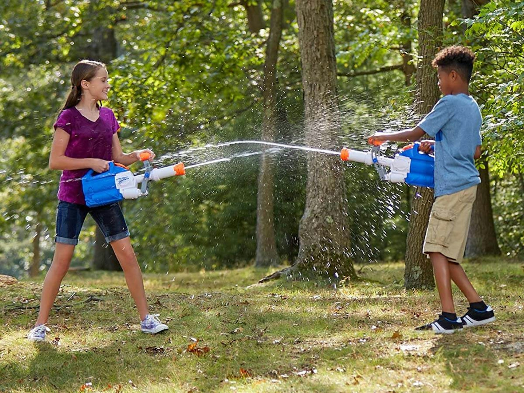 Wasserschlacht im Garten mit Super Soaker Wasserpistolen.