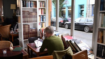 Ein Besucher sitzt im Café Goldmund zwischen Büchern