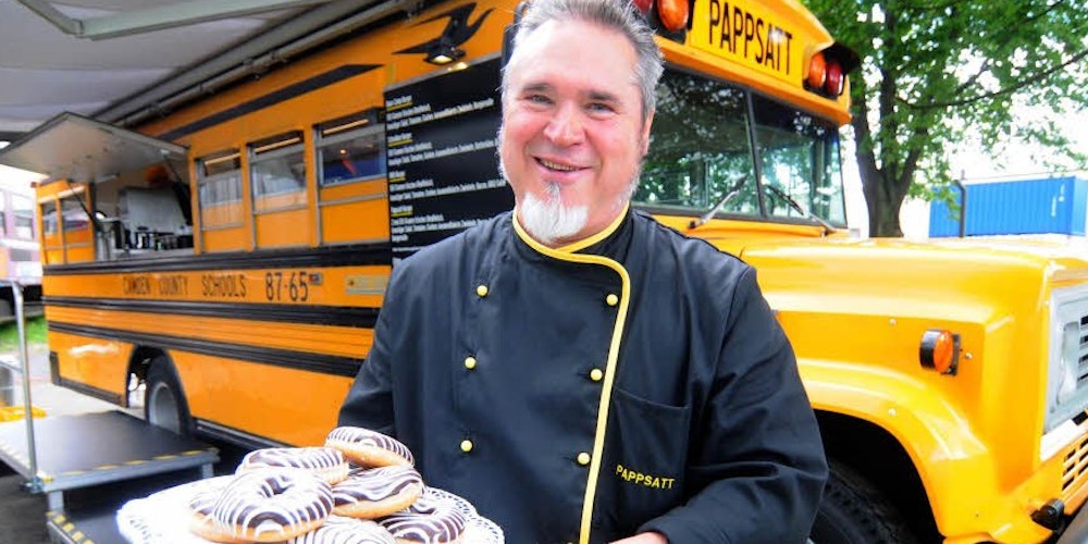 „Guten Appetit“ wünscht Peter Genske, der einen amerikanischen Schulbus zum „Pappsatt“-Restaurant umgebaut hat. (Foto: Sascha Engst)