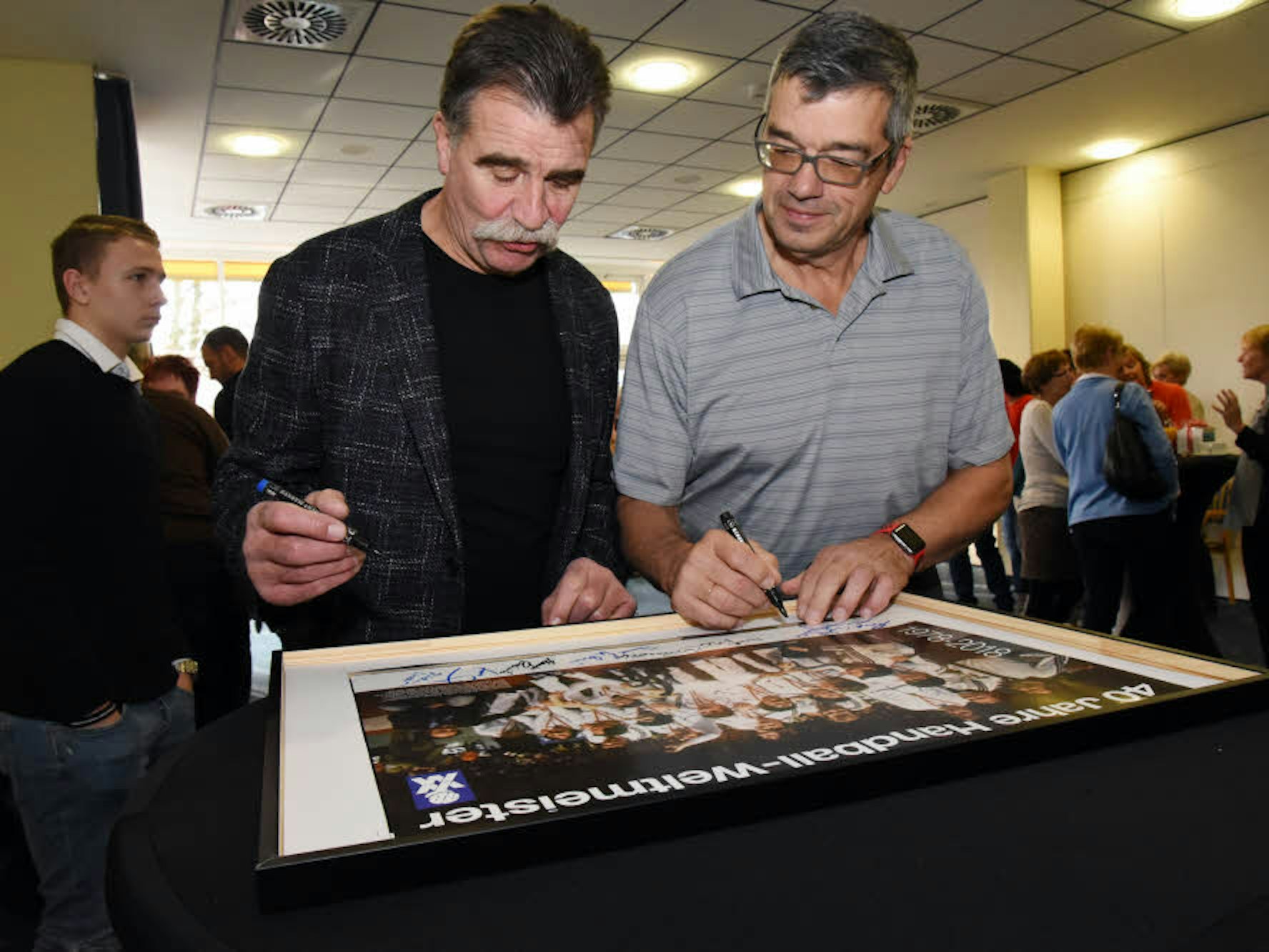 Signierten gemeinsam das Mannschaftsfoto des Weltmeisterteams von 1978: Claus Fey (r.) und Heiner Brand.