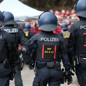 Polizisten stehen Fußballfans gegenüber.