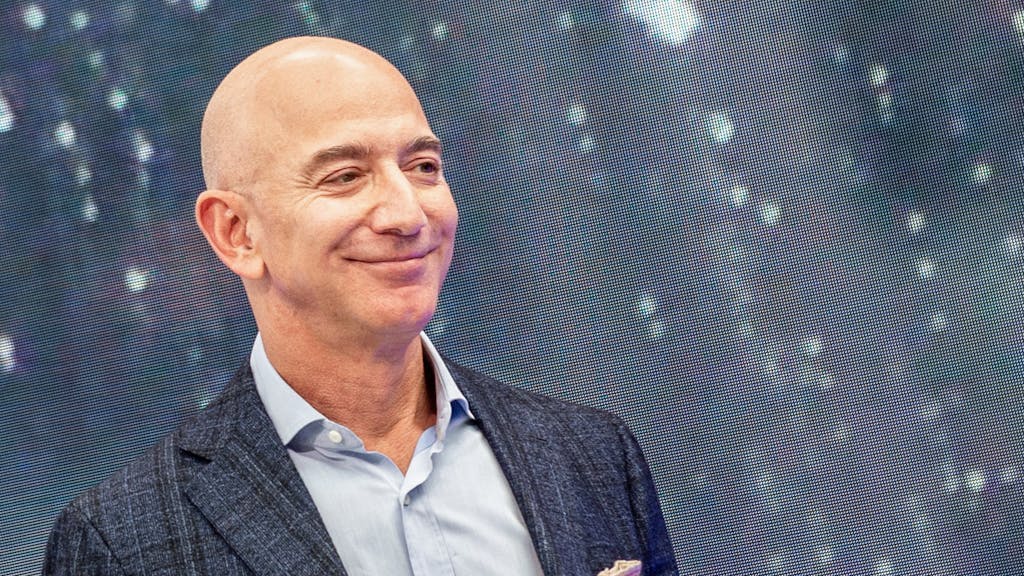 Das undatierte Foto zeigt den Amazon-Gründer Jeff Bezos in dunkler Anzugjacke und hellem Hemd. Er lächelt.