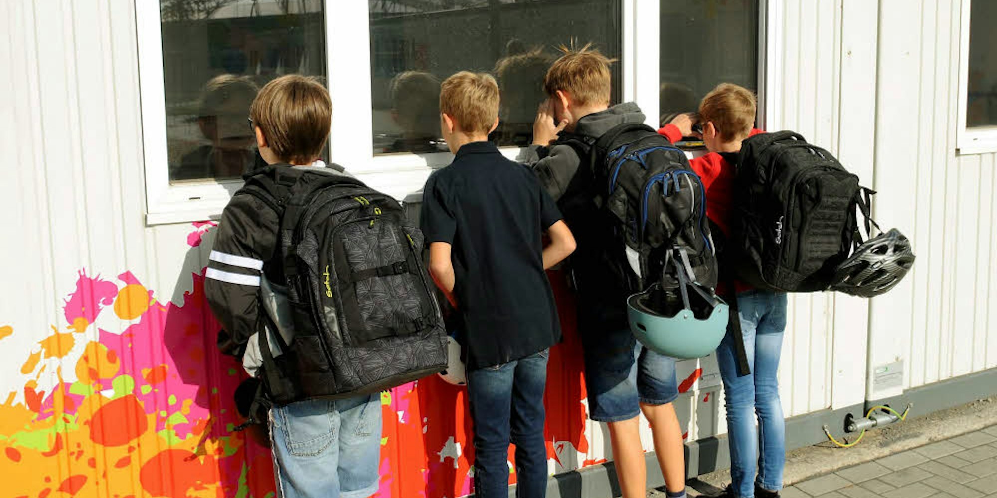 Ein neugieriger Blick ins Container-Innere: Die neuen Fünftklässler schauen am ersten Schultag vorm Unterrichtsbeginn durchs Fenster.