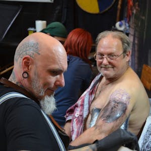 Konzentriert bei der Arbeit ist Tattoo-Künstler Kris Danen aus den Niederlanden, der Mario Minich ein neues Werk auf den Arm sticht.