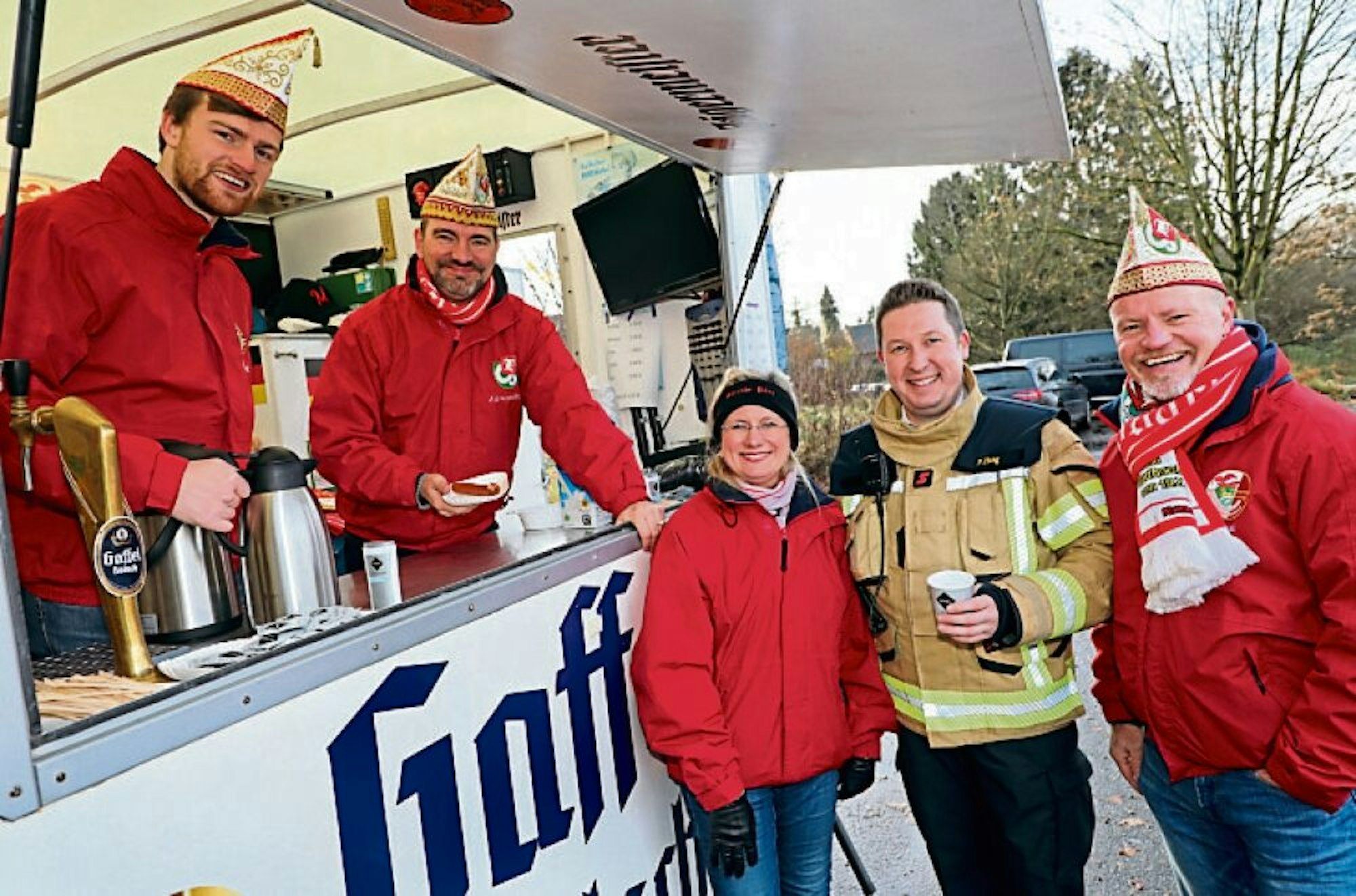 Kaffee und Würstchen bietet die Große Gladbacher KG mit ihrem designierten Dreigestirn um Vize-Feuerwehrchef Frank Haag (2.v.r.) an.