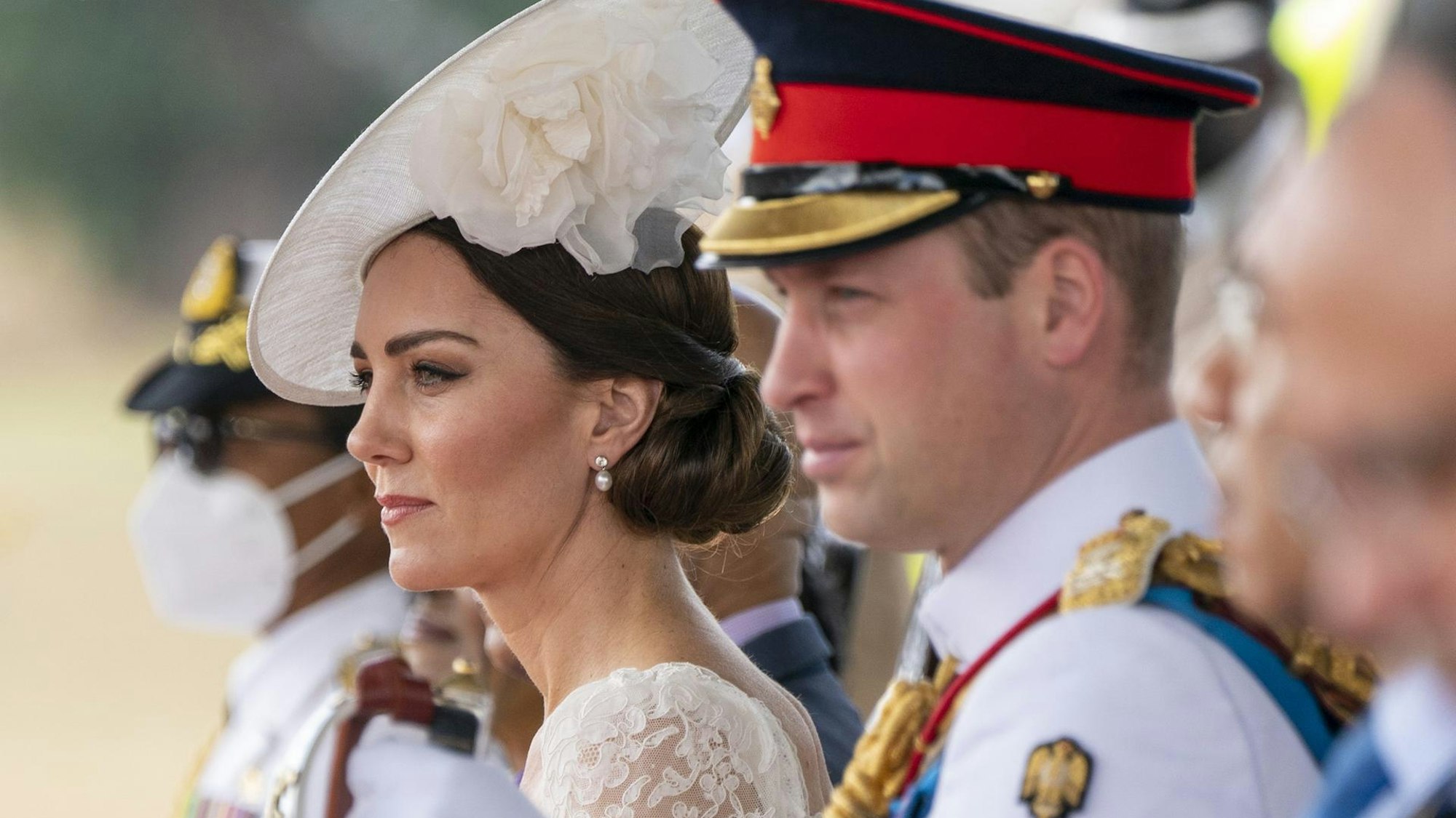 Prinzessin Kate und Prinz William schauen seitlich auf eine Parade.