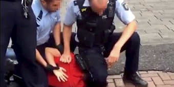 Szene aus dem Video: Beamte fixieren jungen Mann per Knieeinsatz. 